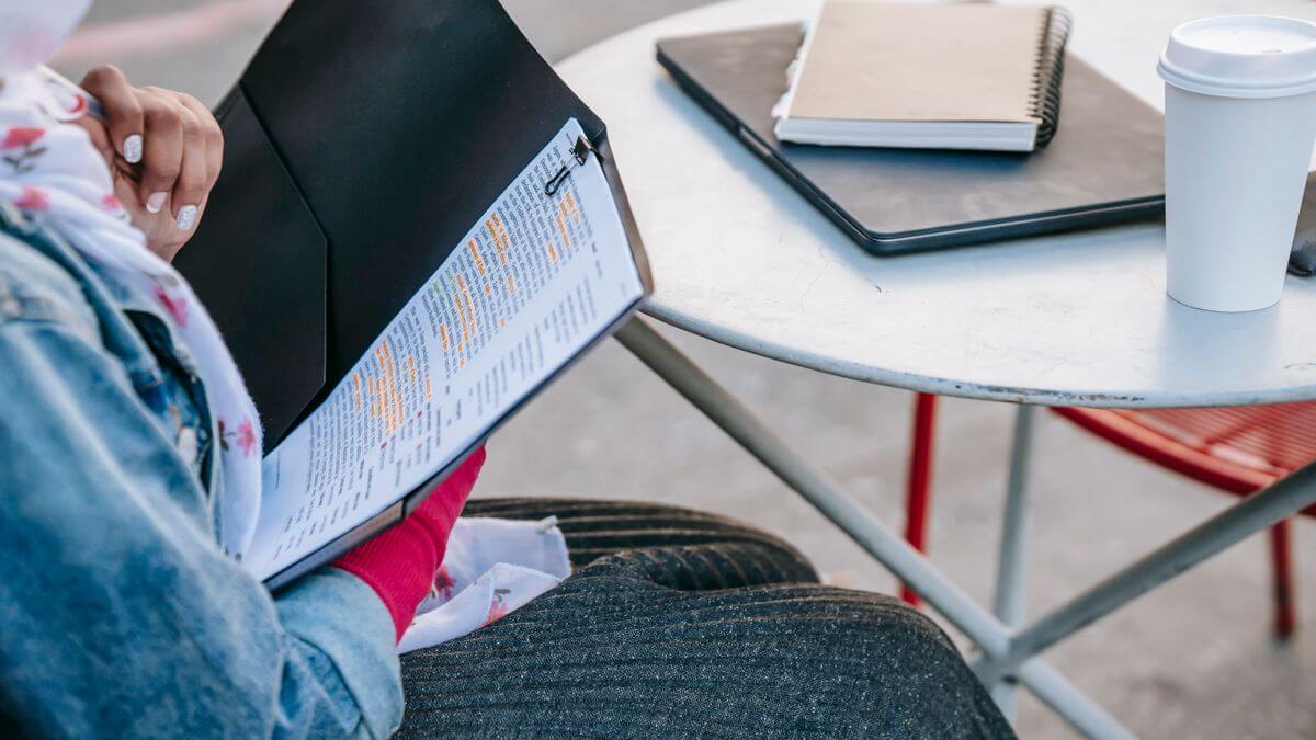 Estudante organizando os documentos do visto de estudante para a França em uma pasta sobre a mesa